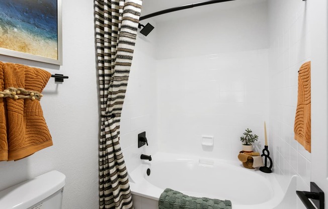 a white bathroom with a tub and a shower curtain