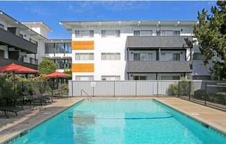 3 stories white building and pool