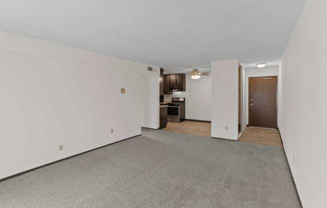 a living room with white walls and a gray carpet