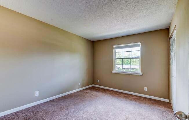 an empty room with carpet and a window