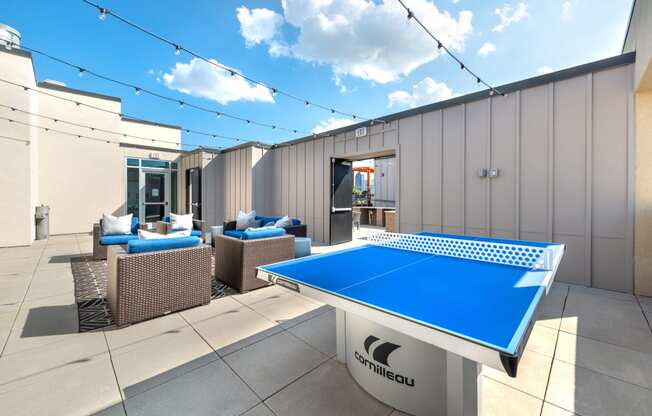 Outdoor sitting area next to a ping pong table and grilling area