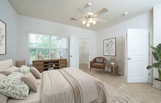 A bedroom with a large bed and a ceiling fan.