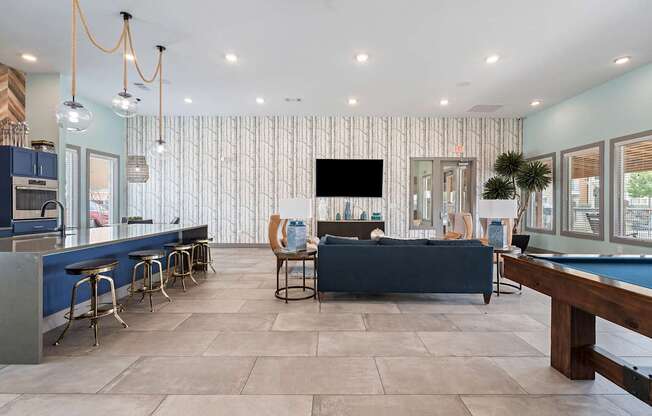 A modern living room with a pool table and a television.