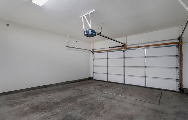the interior of a garage with white walls and a concrete floor