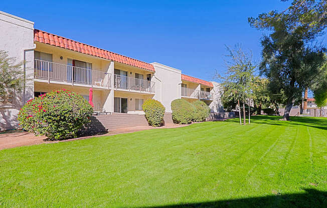 A building with a red roof and a green lawn in front.
