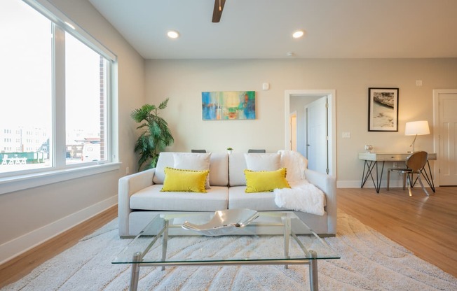 a living room with a couch and a glass coffee table