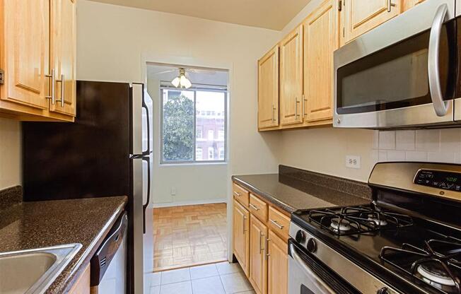 kitchen with stainless steel appliances, and view of dining area with hardwood floors at brunswick house apartments in dupont circle washington dc