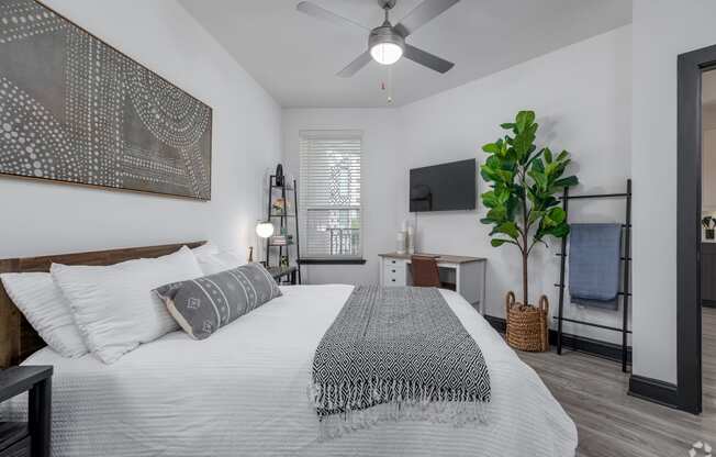 a bedroom with a large bed and a ceiling fan