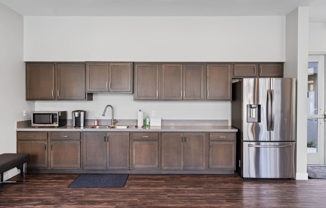 a kitchen with wooden cabinets and a stainless steel refrigerator at Loma Villas Apartments, California, 92408