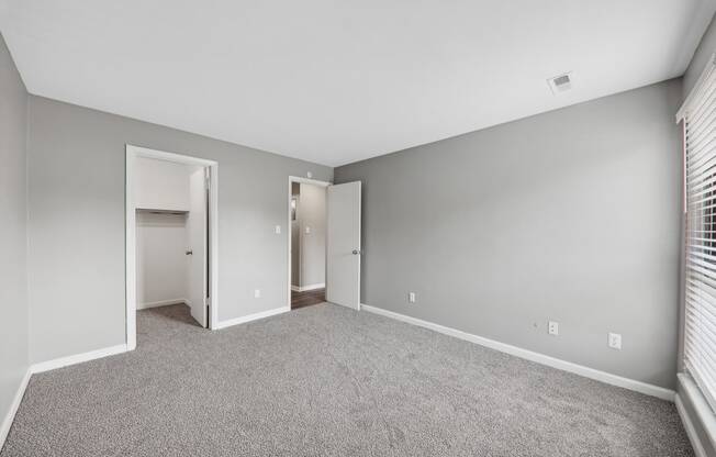 an empty living room with gray walls and carpet