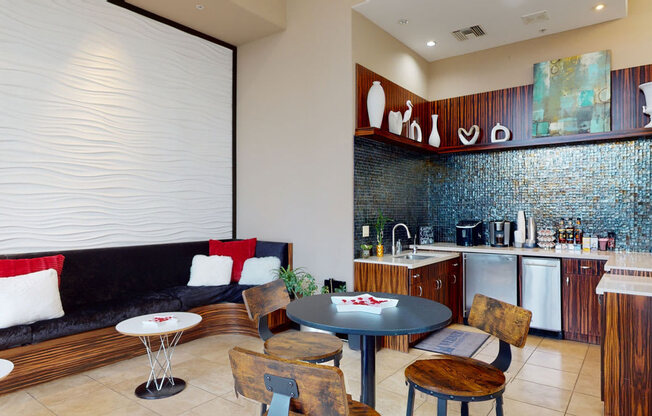 a living room with a couch a table and chairs and a kitchen with a sink and dish