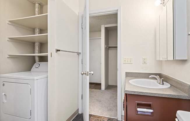 a bathroom with a washer and dryer and a sink and a laundry room