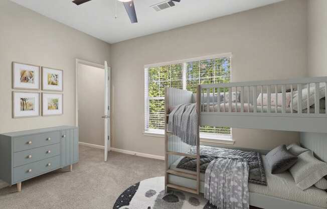 Model apartment bedroom with a bunk bed and a window