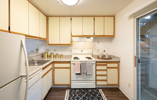 Kitchen with White Kitchen Appliances, Spacious Countertops, and Wood-Style Floors at Laurel Creek, Fairfield, California