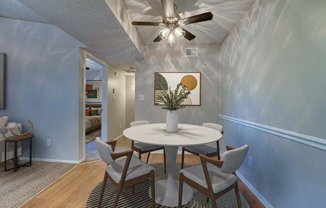 A dining room with a white table and chairs.
