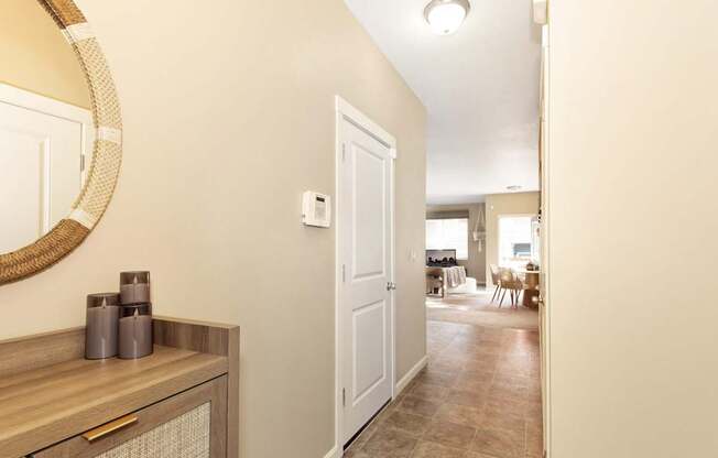 A hallway with a white door and a mirror on the wall at The Landing Apartments and Townhomes, Oregon, 97045