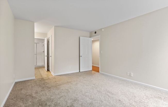 a bedroom with white walls and a carpeted floor