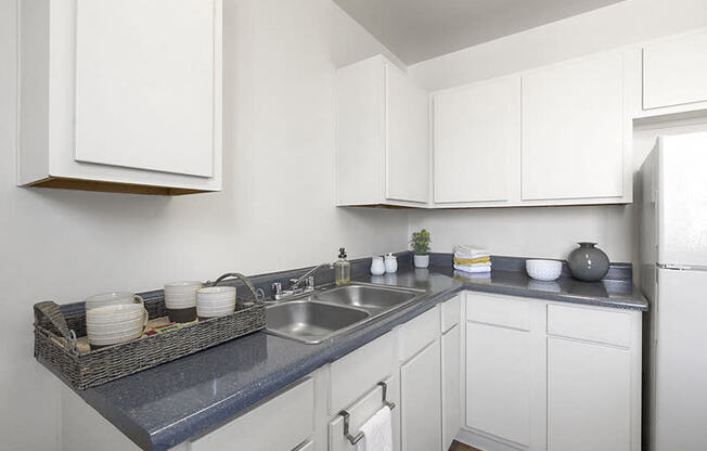 a kitchen with white cabinets and a blue counter top