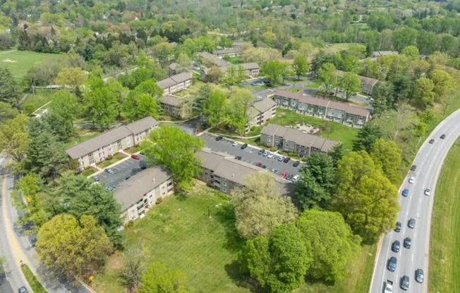 An aerial view of a road with cars and apartment buildings.