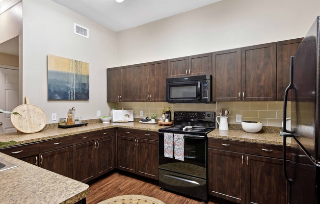 Kitchens feature black appliances, stylish tile backsplash, and Shaker-style cabinetry.