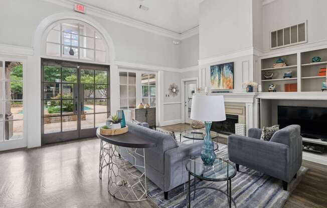 Resident lounge area with grey couches and a glass table at Jefferson Place Apartments in Irving, TX