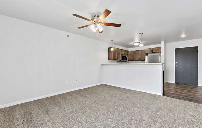 A room with a ceiling fan and carpeted floor.