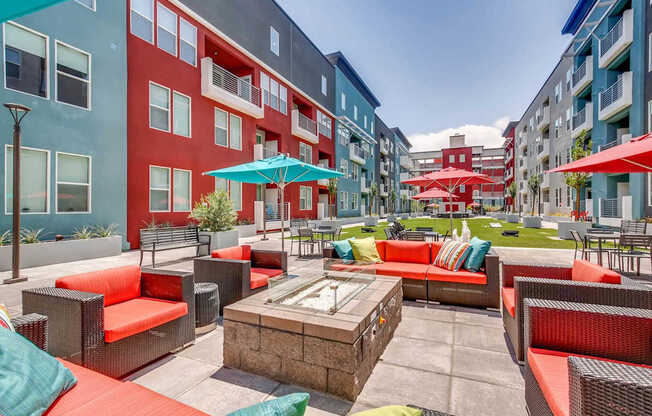 A patio with red couches and a fire pit.