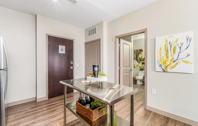 a kitchen with a table and a door to a bathroom