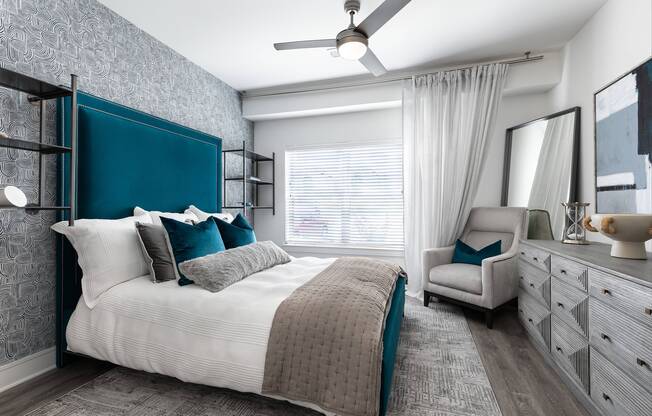 Spacious bedroom with ceiling fan, lofty 9-ft. ceilings, and oversized windows for natural light at Cyan Craig Ranch apartments for rent