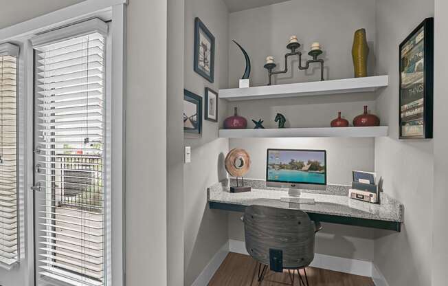 a home office with a computer desk and a window