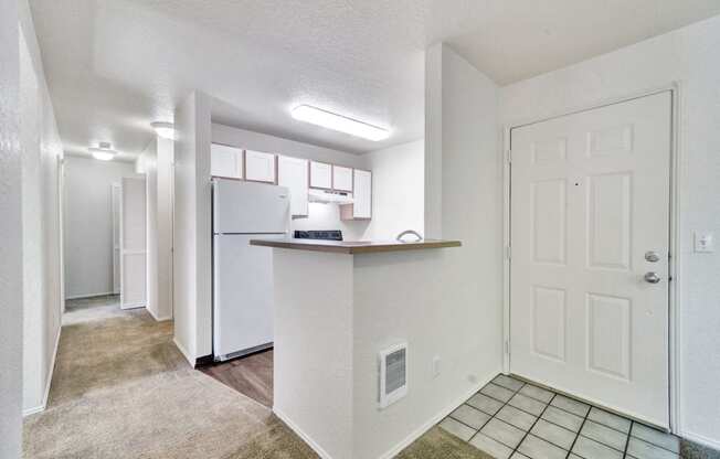 a kitchen with a white refrigerator and a white door