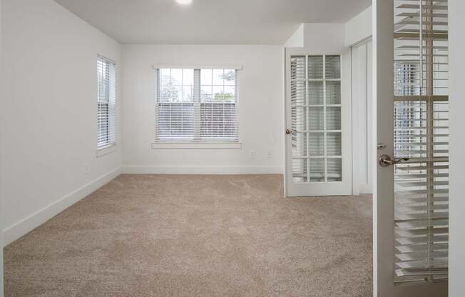 A room with a carpeted floor and a door with a window.