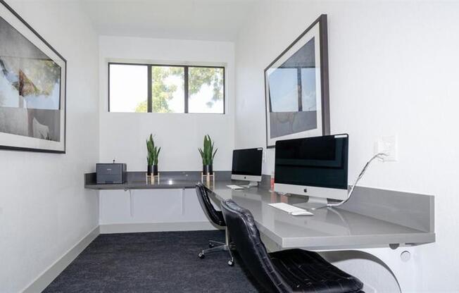 a desk with two computer monitors on top of it