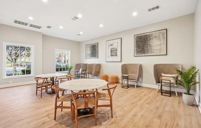 A room with wooden floors and furniture, and three pictures on the wall.