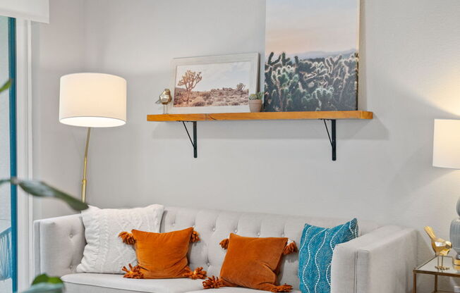 A living room with a white couch, a wooden chair, and a ceiling fan.