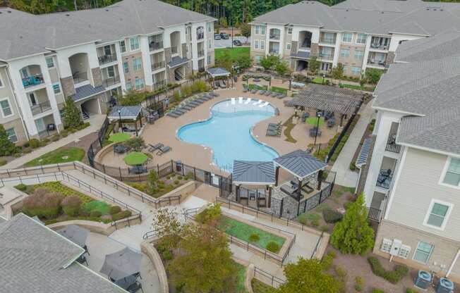 an aerial view of an outdoor pool area with apartment buildings