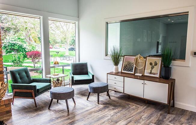 A living room with a green chair and a grey ottoman.