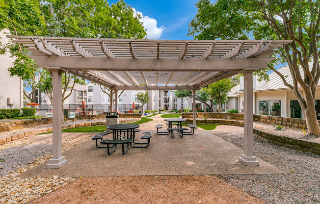 a picnic area with benches and a pergola