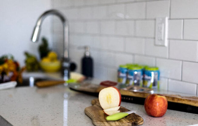 a kitchen counter with an apple on a cutting board