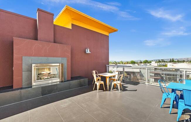 A patio with a table and chairs overlooking a cityscape.
