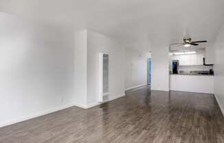 an empty living room with white walls and wood flooring