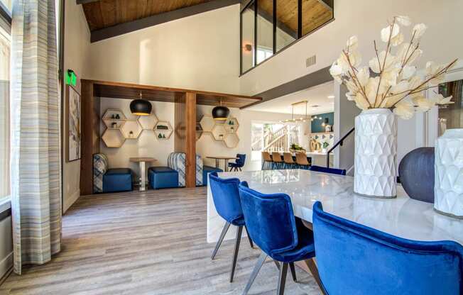 a dining room table with blue chairs and a vase of flowers  at Veranda La Mesa, La Mesa