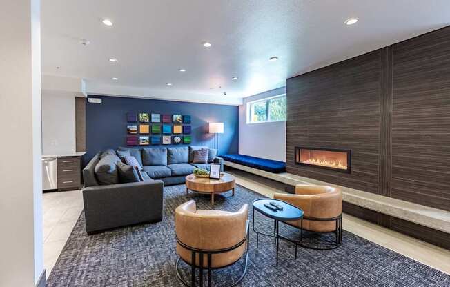 A modern living room with a fireplace and a grey sofa. at Kirkland Crossing Apartments, Kirkland, WA, 98033