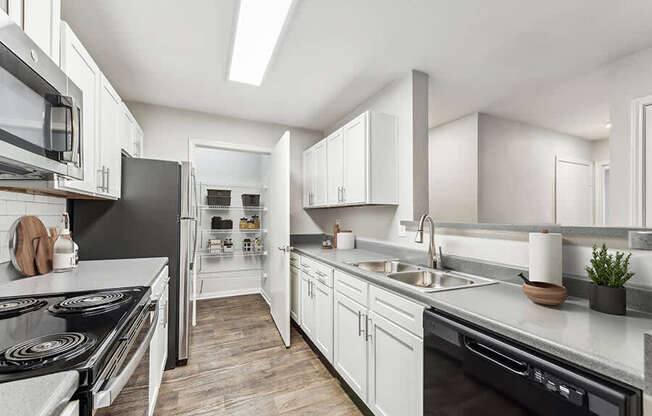 Model Kitchen with White Cabinets and Wood-Style Flooring at Lake Cameron Apartments located in Apex, NC.