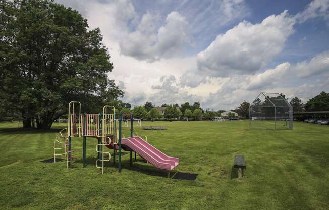 a playground with a slide and a bench in a park at Village Club of Rochester Hills, Shelby Township Michigan