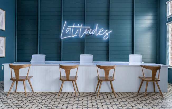 a bar with chairs and a neon sign on the wall