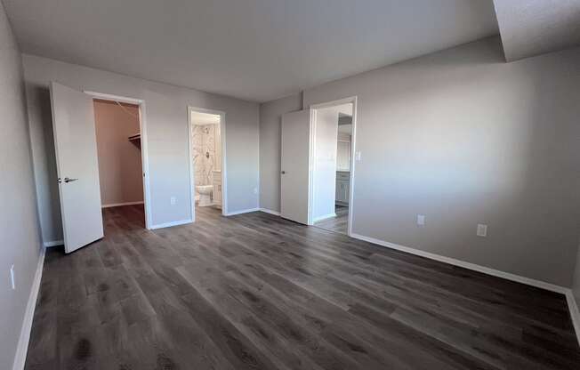 an empty living room with hard wood floors and white walls