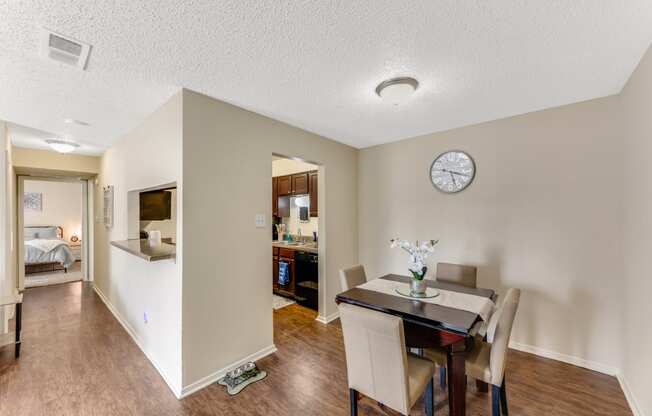 a dining room with a table and chairs and a clock on the wall