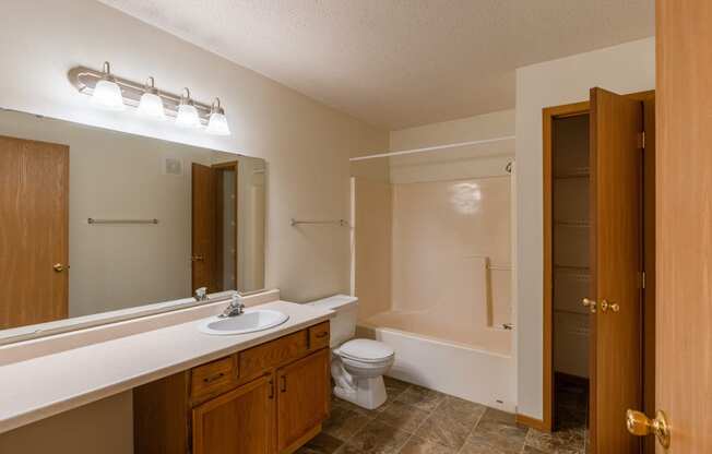 a bathroom with a sink toilet and bathtub.  Fargo, ND Sunwood Apartments  | Living and kitchen Fargo, ND Sunwood Apartments