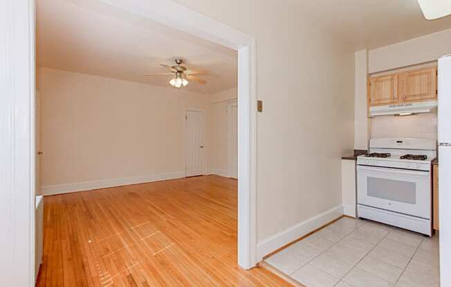 kitchen with wood cabinetry, gas range and view of living area at parkside apartments in washington dc